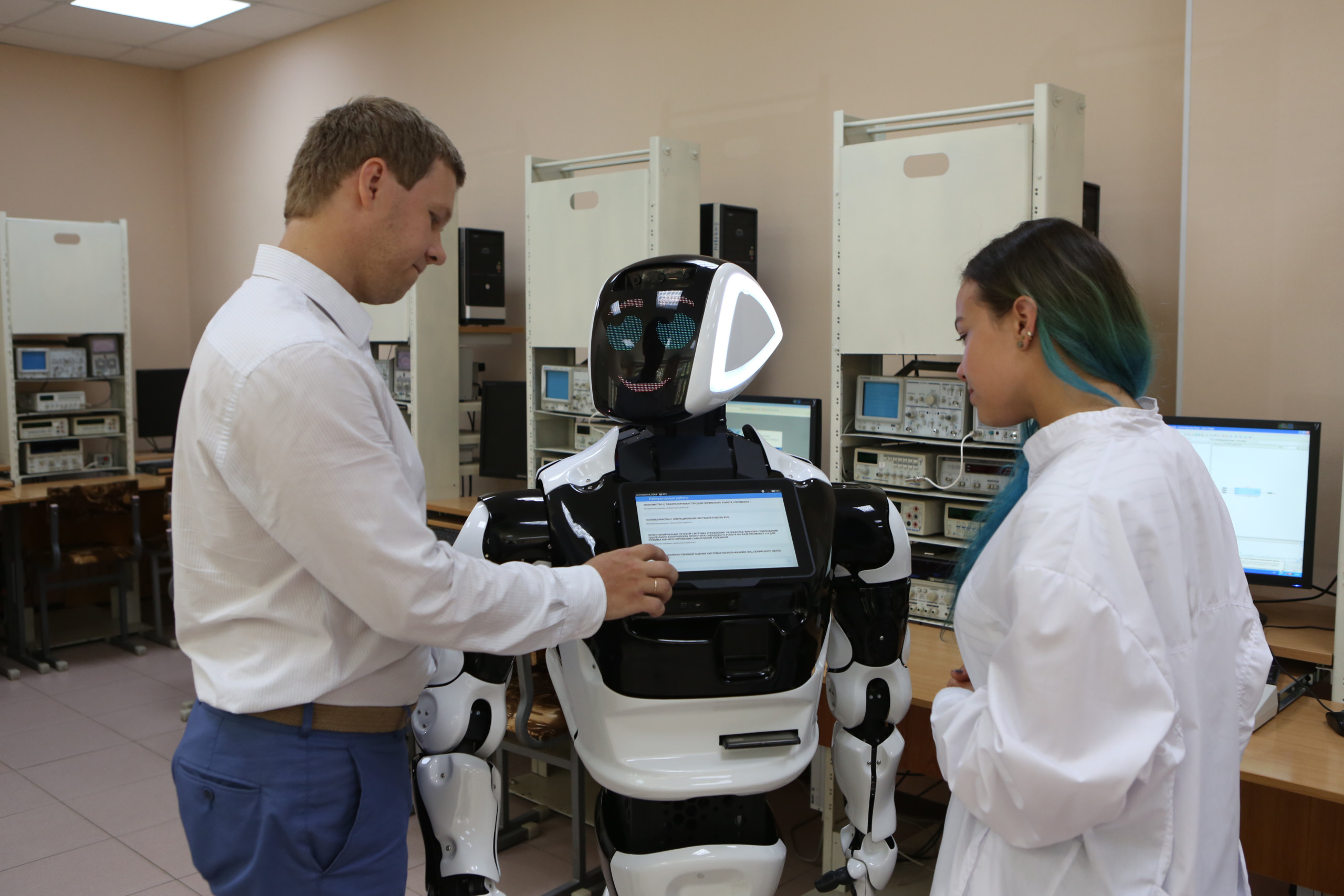 Homem e mulher interagindo com inteligência artificial do Robô Máximus, em um laboratório
