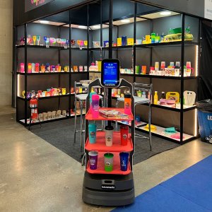 Robô nik em ação promocional expondo copos como produtos em frente a stand