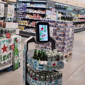 Robô Nik customizado com adesivos da Heineken, expondo garrafas e latas em suas bandejas