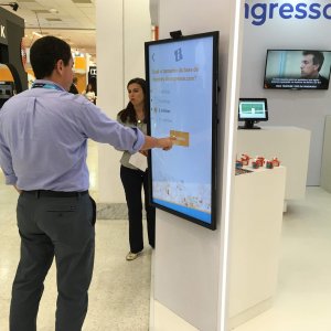 Pessoa interagindo com Quiz do Ingresso.com, no stand do Ingresso.com